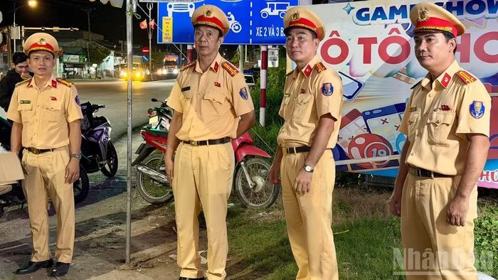 Đại tá Thái Viết Vũ, Trưởng Phòng Cảnh sát giao thông (Công an tỉnh Đồng Tháp) (thứ 2 từ trái sang) kiểm tra công tác phát quà cho người dân tại "Trạm dừng chân nghĩa tình" trên Quốc lộ 1, xã Mỹ Đức Tây.