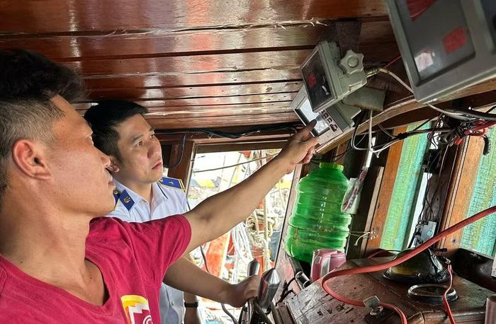 Kiểm tra thiết bị giám sát hành trình trên tàu cá có dấu hiệu vi phạm. (Ảnh: Cảnh sát biển cung cấp)