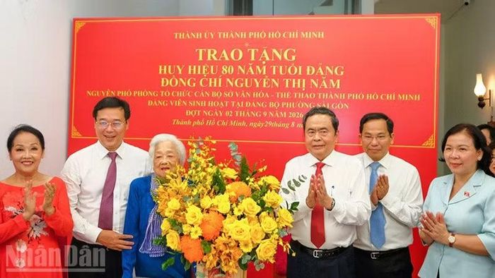 Chủ tịch Quốc hội Trần Thanh Mẫn và các đồng chí lãnh đạo chúc mừng đồng chí Nguyễn Thị Năm nhận Huy hiệu 80 năm tuổi Đảng. (Ảnh: Thế Anh)