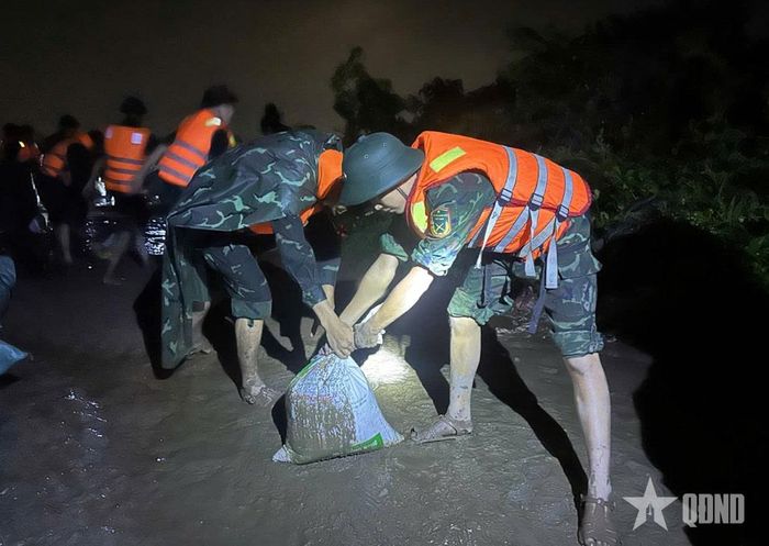 Cán bộ, chiến sĩ LLVT tỉnh Quảng Ninh tham gia khắc phục sự cố tràn đê Cây Thau thuộc khu Điền Công 3, phường Uông Bí.