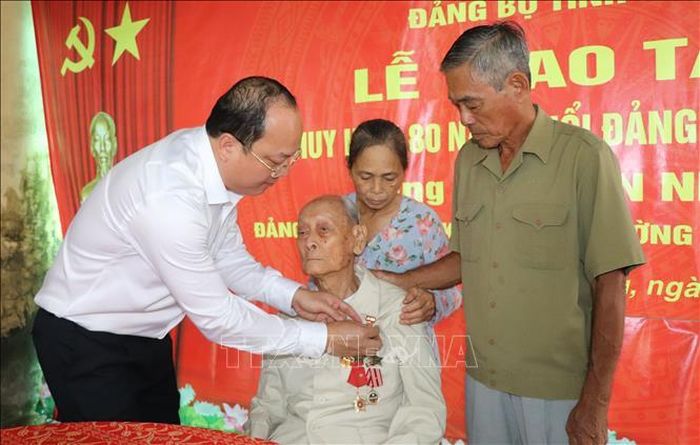  Bí thư Tỉnh ủy Cà Mau Nguyễn Hồ Hải trao Huy hiệu 80 năm tuổi Đảng tặng đảng viên Trần Nhượng. 