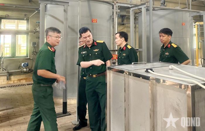 Thiếu tá Nguyễn Văn Huống (ngoài cùng bên trái) kiểm tra hệ thống xử lý nước thải tại Nhà máy Z113. Ảnh: TUẤN ANH