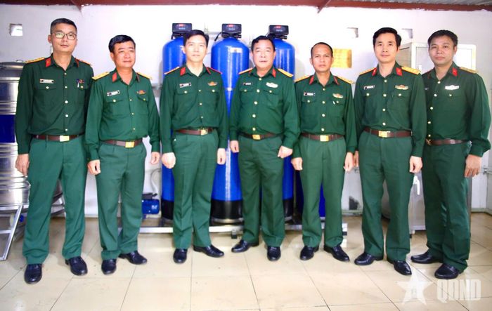 Thiếu tá Nguyễn Văn Huống (ngoài cùng bên trái) tham gia đoàn công tác bàn giao hệ thống lọc nước tinh khiết tại Quân khu 3. Ảnh: TUẤN ANH