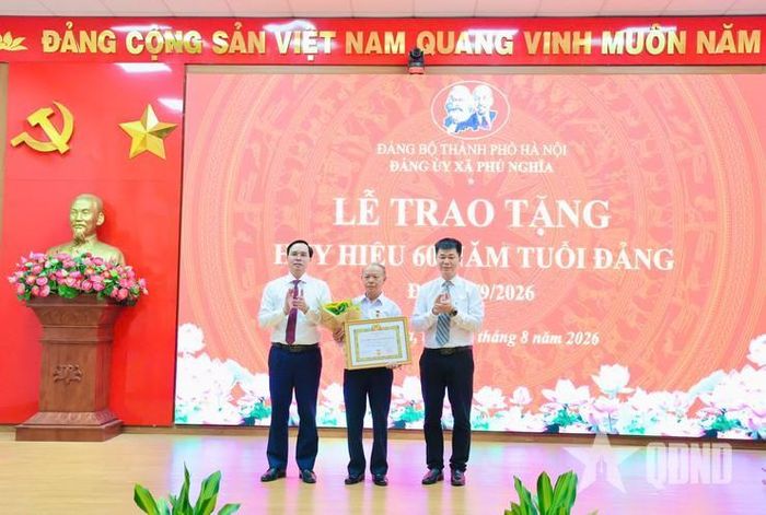 Đồng chí Nguyễn Văn Toàn (ngoài cùng bên phải), Phó trưởng Ban Nội chính Thành ủy Hà Nội và đồng chí Trịnh Tiến Tường (ngoài cùng bên trái), Bí thư Đảng ủy, Chủ tịch HĐND xã Phú Nghĩa trao tặng Huy hiệu 60 năm tuổi Đảng cho đồng chí Nguyễn Hữu Chăm, đảng viên Chi bộ thôn Phù Yên.