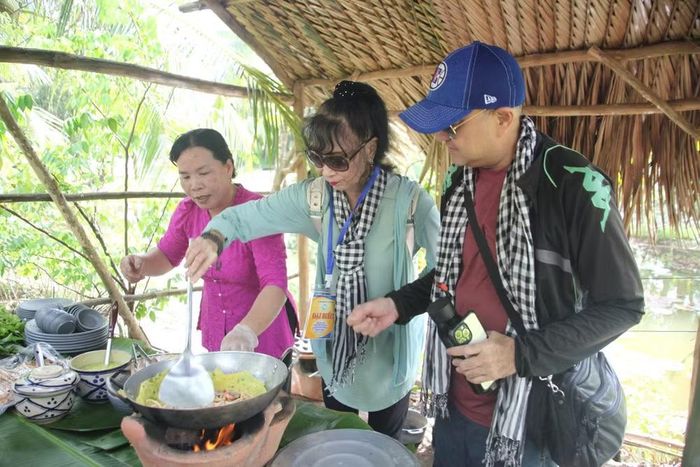 Các thành viên đoàn Presstrip trải nghiệm làm bánh xèo.
