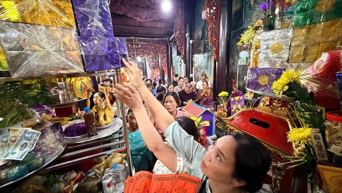 Khu vực chính điện chật kín người. Nhiều du khách phải đội mâm lễ trên đầu, len qua dòng người để vào bên trong dâng hương.