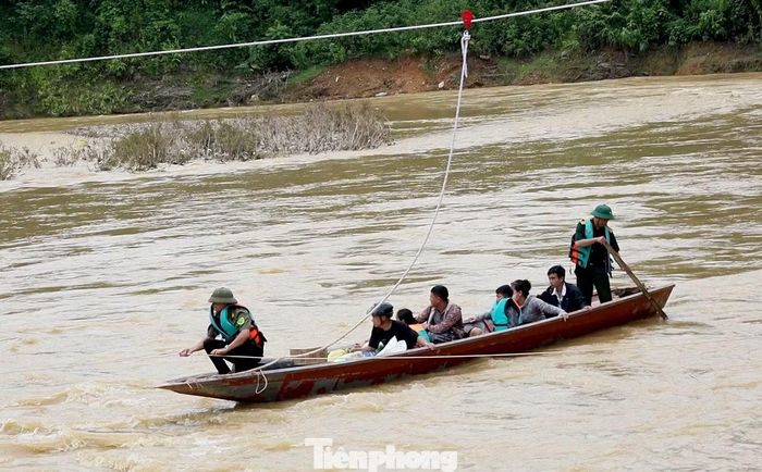 Những chuyến thuyền ngược xuôi chở người dân ra, vào bản. Do nước chảy xiết, đơn vị chức năng phải dùng dây nối 2 bên bờ sông để níu thuyền cho an toàn.