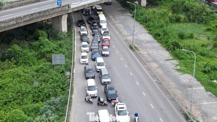 Các làn đường chật kín ôtô. Tại khu vực vòng xoay Liên Phường, dòng phương tiện nối dài, di chuyển chậm chạp