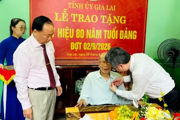 Trưởng Ban Chính sách, chiến lược Trung ương Nguyễn Thanh Nghị gắn huy hiệu 80 năm tuổi Đảng cho đồng chí Phan Ngọc Bích.