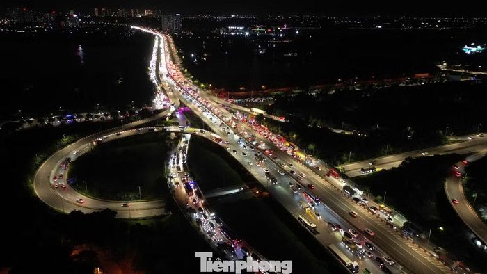 Càng về phía cầu Thanh Trì, mật độ phương tiện trên vành đai 3 trên cao càng tăng. Nhiều ô tô mang biển kiểm soát ngoại tỉnh nối đuôi rời Hà Nội.