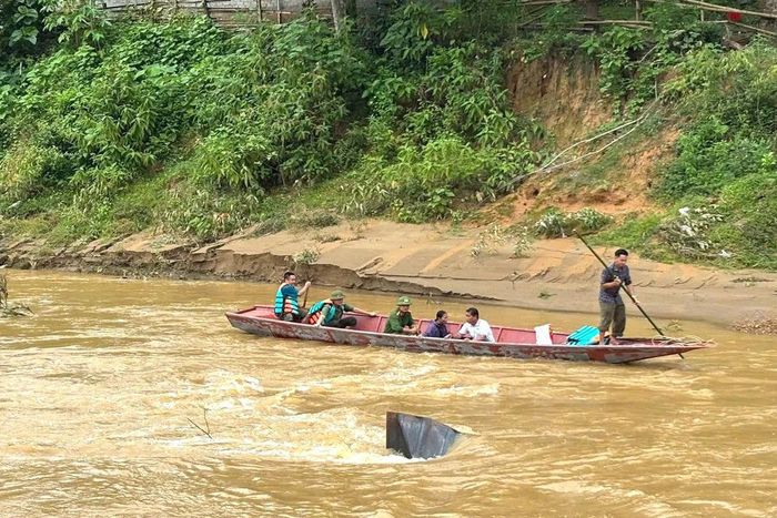 Lực lượng chức năng xã Yên Hòa dùng thuyền hỗ trợ người dân qua sông sau khi cầu Trung Thắng bị lũ cuốn.