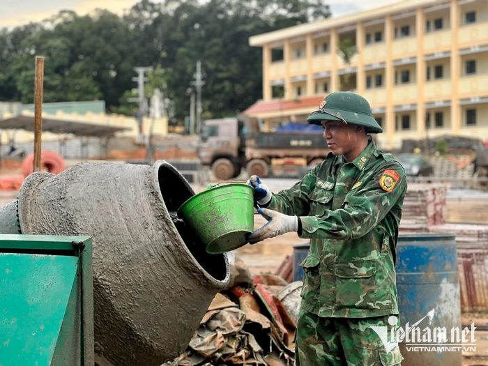 Các cán bộ, chiến sĩ làm việc bất kể nắng mưa để sớm hoàn thành công trình trường học. Ảnh: Ngọc Thu