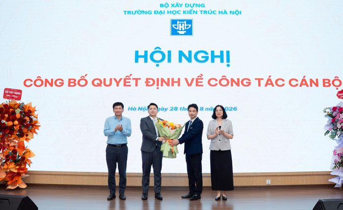 PGS.TS Vũ Ngọc Anh, Hiệu trưởng Trường ĐH Kiến trúc Hà Nội cùng tập thể ban giám hiệu tặng hoa chúc mừng PGS.TS Trần Trung Hiếu. Ảnh: HAU
