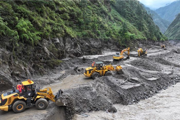 Máy móc làm việc tại những đoạn đường bị ảnh hưởng bởi sạt lở đất để khôi phục giao thông ở huyện Gyirong, thuộc Khu tự trị Tây Tạng. Ảnh: CCTV