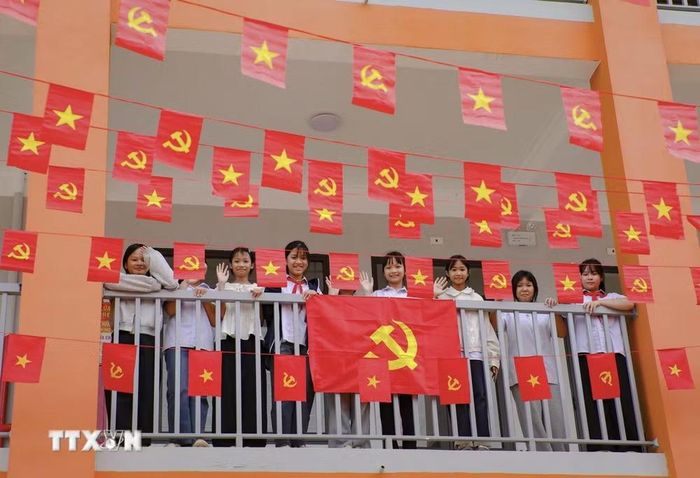 Học sinh Trường Phổ thông nội trú Tiểu học và THCS Sam Mứn tươi vui bên những lá cờ Đảng, cờ Tổ quốc được trang trí trên hành lang. (Ảnh: Xuân Tư/TTXVN)
