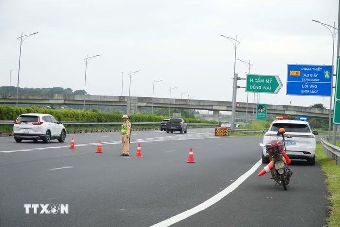 Lực lượng chức năng đặt cảnh báo giao thông hướng dẫn luồng di chuyển phương tiện trên cao tốc Thành phố Hồ Chí Minh-Long Thành-Dầu Giây hướng đi Phan Thiết. (Ảnh: Sỹ Tuyên/TTXVN)