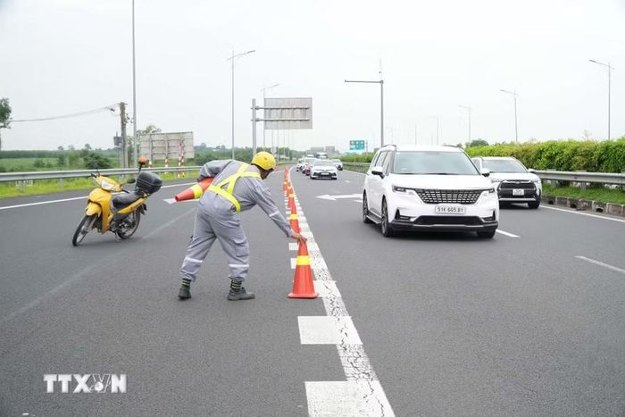 Lực lượng chức năng đặt cảnh báo giao thông hướng dẫn luồng di chuyển phương tiện trên cao tốc Thành phố Hồ Chí Minh-Long Thành-Dầu Giây hướng đi Phan Thiết. (Ảnh: Sỹ Tuyên/TTXVN)