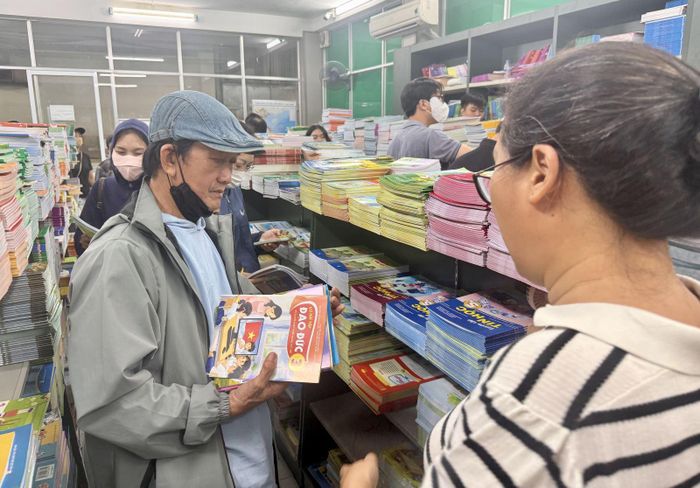 Nhân viên Nhà xuất bản hỗ trợ phụ huynh tìm sách.