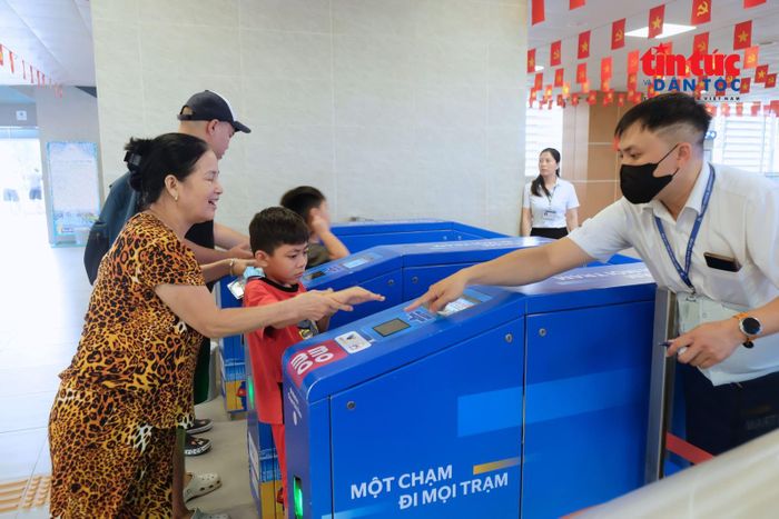 Nhân viên ga tức trực hướng dẫn hành khách sử dụng hệ thống soát vé tự động, lan tỏa hình ảnh một Thủ đô văn minh, hiện đại và thân thiện trong mắt người dân và du khách.