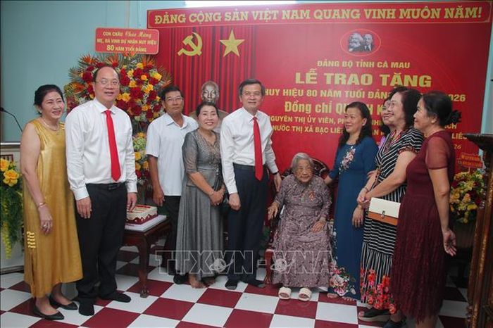 Đồng chí Đoàn Minh Huấn, Ủy viên Bộ Chính trị, Giám đốc Học viện Chính trị quốc gia Hồ Chí Minh và đồng chí Nguyễn Hồ Hải, Uỷ viên TƯ Đảng, Bí thư Tỉnh ủy Cà Mau chụp ảnh lưu niệm cùng gia đình đồng chí Quách Kim Tuyến tại buổi lễ trao Huy hiệu 80 năm tuổi Đảng. Ảnh: Chanh Đa/TTXVN
