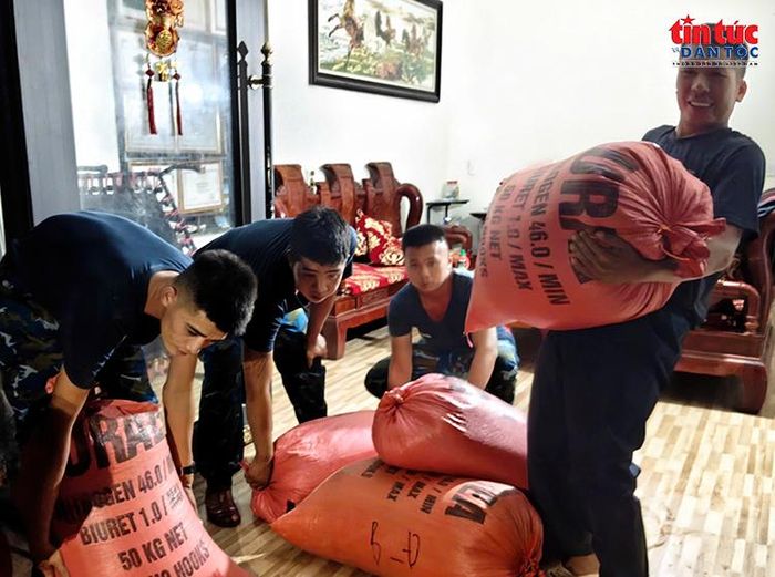 Cán bộ, chiến sĩ hỗ trợ người dân di chuyển, sắp xếp tài sản sau khi nhà ở bị ảnh hưởng bởi ngập lụt.