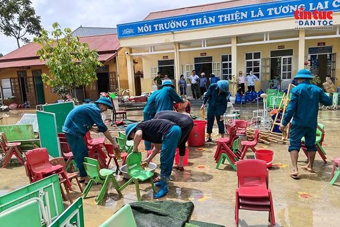 Lực lượng địa phương khẩn trương vệ sinh bàn ghế, đồ dùng học tập tại một trường học trên địa bàn xã Tràng Định.