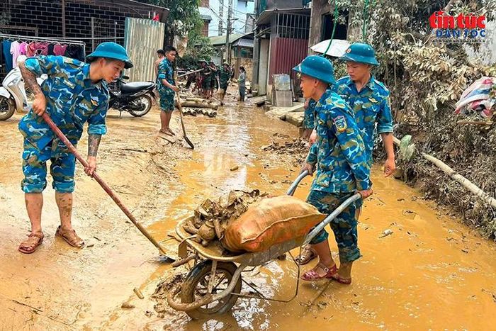 Bộ đội thu gom, vận chuyển cây cối và rác thải còn ngổn ngang sau khi nước lũ rút.