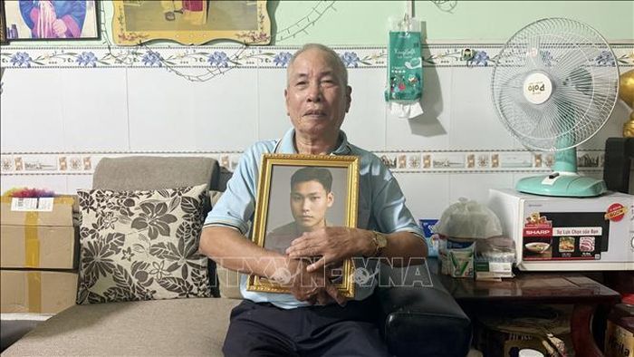 Thân nhân Liệt sĩ Vũ Văn Vững (phường Trảng Dài, thành phố Đồng Nai) xúc động ôm di ảnh người thân.