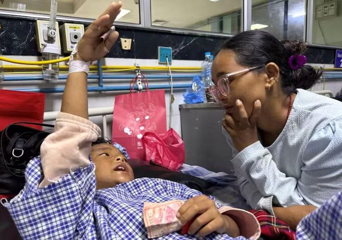 Zoyal Ghale, 8 tuổi, được trực thăng đưa đi cấp cứu từ Rasuwa sau khi bị thương trong trận lũ quét và sạt lở đất kinh hoàng, đang trò chuyện với mẹ mình, Matti Maya Tamang, 28 tuổi, hai ngày sau khi hai mẹ con bị chia cắt do lũ lụt, bên trong một bệnh viện ở Kathmandu, Nepal, ngày 28/8. Ảnh: Reuters.