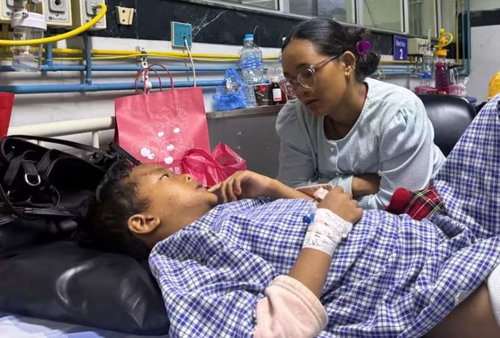 Matti Maya Tamang, 28 tuổi, trò chuyện với con trai Zoyal Ghale, 8 tuổi, tại bệnh viện. Ảnh: Reuters.
