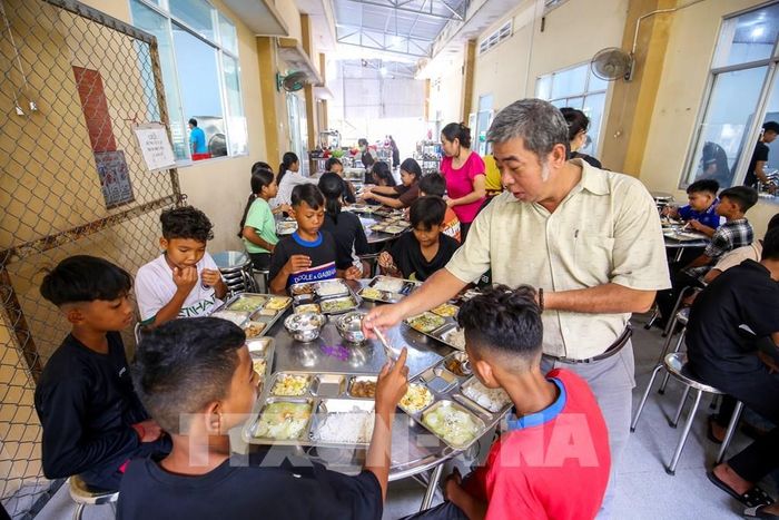 Thầy Lê Minh Trung kiểm tra từng bàn ăn, rà soát các điều kiện phục vụ học sinh tại nhà ăn nội trú. Ảnh: Giang Phương - TTXVN