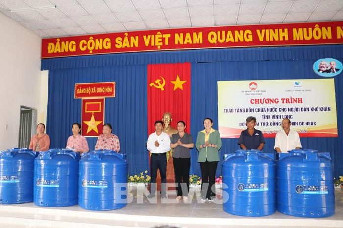 Trao bồn nước cho người dân xã Long Hòa. Ảnh: Thanh Hòa-TTXVN