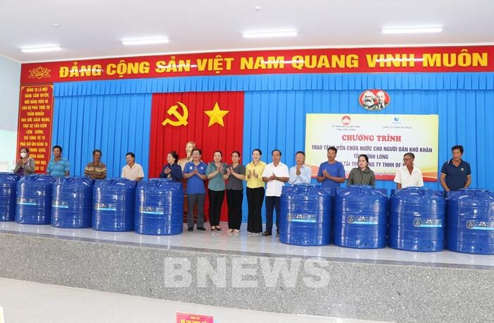 Trao bồn nước cho người dân xã Hòa Minh. Ảnh: Thanh Hòa-TTXVN