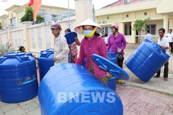 Người dân xã Long Hòa nhận bồn nước. Ảnh: Thanh Hòa-TTXVN