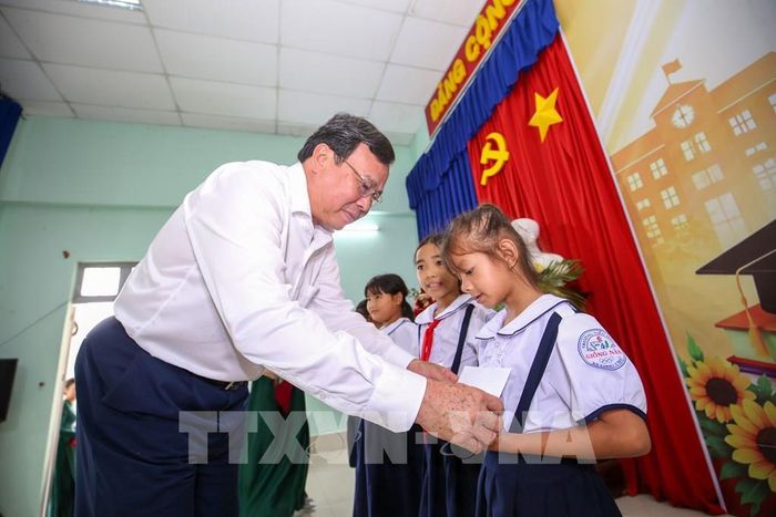 Chủ tịch UBND tỉnh Tây Ninh Lê Văn Hẳn tặng quà, học bổng cho các em học sinh nghèo, hiếu học tại xã Long Chữ, tỉnh Tây Ninh. Ảnh: Giang Phương – TTXVN