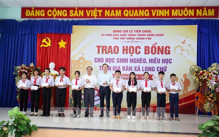 Thứ trưởng Bộ Giáo dục và Đào tạo Đoàn Trung Kiên (giữa, phải) cùng Phó Chủ tịch UBND tỉnh Tây Ninh Nguyễn Hồng Thanh (trái) trao học bổng tặng các em học sinh có hoàn cảnh khó khăn, vượt khó học tốt. Ảnh: Giang Phương - TTXVN