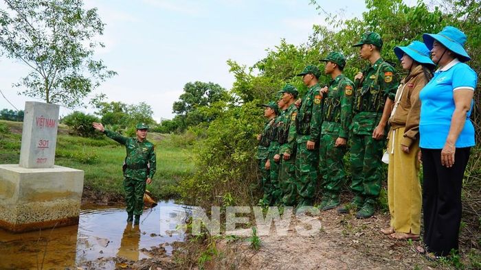 Cán bộ, chiến sĩ Biên phòng An Giang cùng hội viên phụ nữ kiểm tra bảo vệ cột mốc. Ảnh: Văn Sĩ-TTXVN