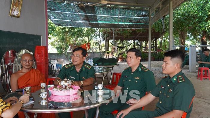 Cán bộ Đồn Biên phòng Phú Mỹ gặp gỡ, trao đổi thông tin với người có uy tín xã Giang Thành. Ảnh: Văn Sĩ-TTXVN