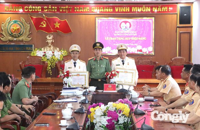 Đại tá Lê Tấn Vinh, Phó Bí thư Đảng ủy, Phó Giám đốc Công an tỉnh trao tặng Huy hiệu 35 năm tuổi Đảng cho Thượng tá Trần Quốc Phong (bên phải) và Huy hiệu 30 năm tuổi Đảng cho Thượng tá Nguyễn Thành Vĩnh (bên trái)