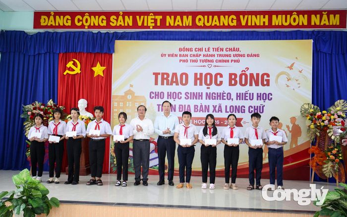 Thứ trưởng Bộ Giáo dục và Đào tạo Đoàn Trung Kiên (thứ 6, từ phải qua) và Ủy viên Ban Thường vụ Tỉnh ủy, Phó Chủ tịch Thường trực UBND tỉnh Nguyễn Hồng Thanh trao học bổng cho các em học sinh. Ảnh: Sỹ Công.