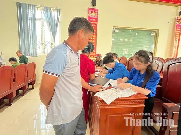 Đoàn thanh niên phường Ngọc Sơn hướng dẫn thân nhân liệt sĩ kê khai thông tin đăng ký lấy mẫu ADN. (Ảnh địa phương cung cấp)