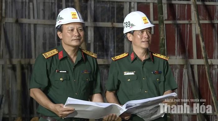 Thượng tá Nguyễn Xuân Hải, Phó Trưởng phòng Kế hoạch - Kỹ thuật và Kinh doanh, Tổng Công ty 789 - Bộ Quốc phòng (bên trái) cho biết: “Để huy động được hơn 400 con người làm việc ngày đêm tại công trình, ngoài quân số huy động từ những ngày đầu, từ tháng 8/2026 chúng tôi tăng cường thêm khoảng 100 người ở Tổng Công ty ngoài Hà Nội vào. Ngoài ra, lực lượng Quân đội với 120 chiến sĩ cũng được cơ quan chức năng tỉnh Thanh Hóa điều động hỗ trợ để thi công kịp khai giảng năm học mới”.