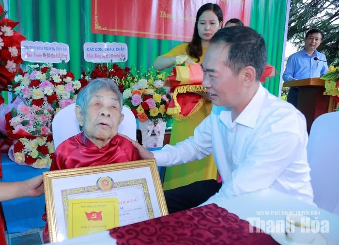 Phó Bí thư Tỉnh ủy Trịnh Tuấn Sinh trao Huy hiệu 80 năm tuổi Đảng cho đảng viên Nguyễn Thị Xe.