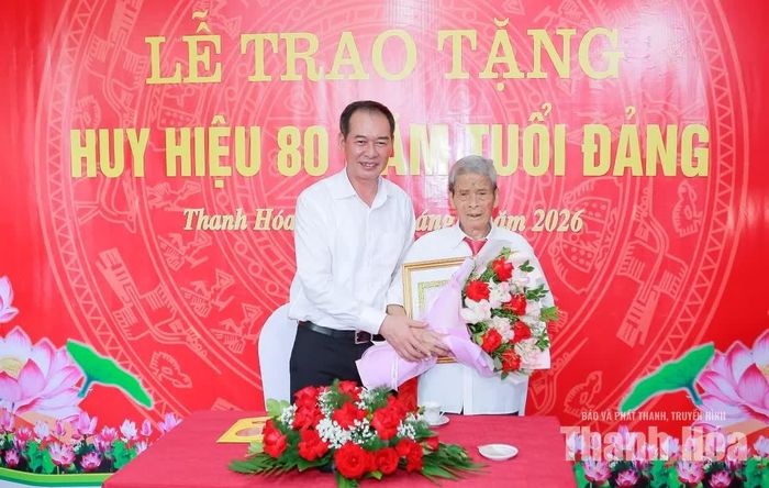 Phó Bí thư Tỉnh ủy Trịnh Tuấn Sinh trao Huy hiệu 80 năm tuổi Đảng và tặng hoa chúc mừng đảng viên Trịnh Xuân Bảy.