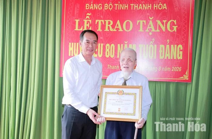 Phó Bí thư Tỉnh ủy Trịnh Tuấn Sinh trao Huy hiệu 80 năm tuổi Đảng cho đảng viên Lê Thế Dực.
