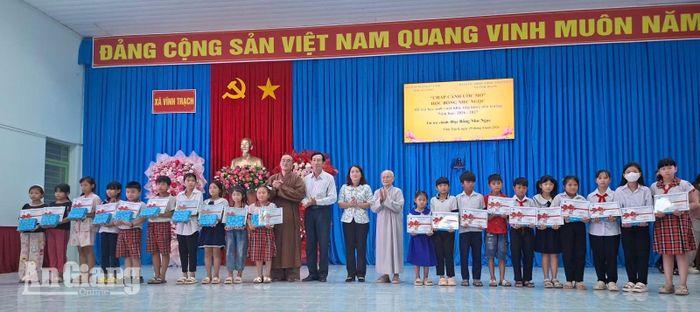 Trao quà cho học sinh vượt khó học giỏi các xã Vĩnh Trạch, Phú Hòa và Định Mỹ. Ảnh: MỸ NGA