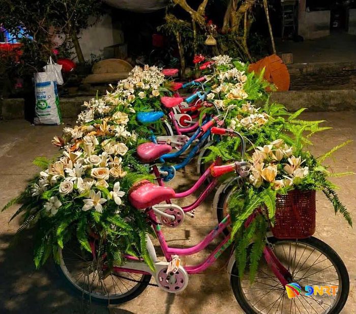 Xe đạp trang trí hoa bằng mo cau được bố trí cho du khách tới chụp hình lưu niệm. Ảnh: D.LỆ