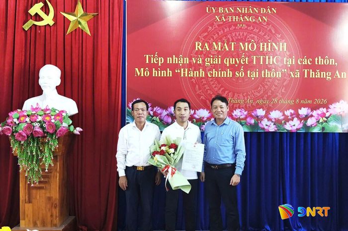 Lãnh đạo xã Thăng An trao kết quả và tặng hoa chúc mừng công dân khi thực hiện thủ tục hành chính tại buổi ra mắt mô hình. Ảnh: HỒNG NĂM