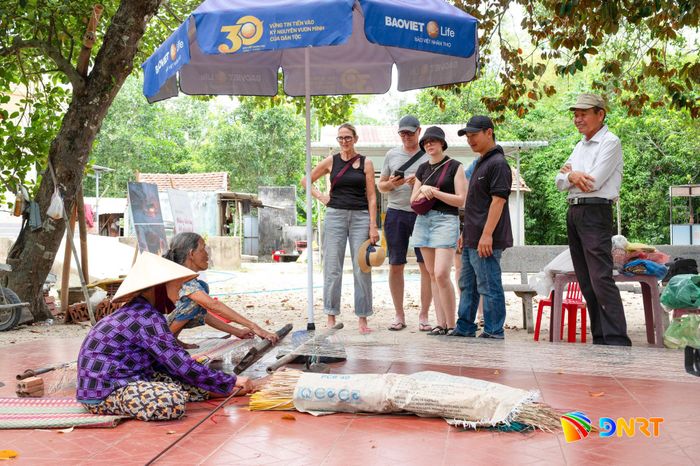 Khách du lịch tham quan Địa đạo Kỳ Anh và thích thú với cách làm chiếu cói. Ảnh: HOÀNG ĐẠO