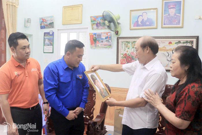 Đại diện Thành đoàn và Trường cao đẳng FPT Polytechnic tại Đồng Nai trao tặng ảnh phục dựng cho gia đình liệt sĩ Lương Xuân Bảo. Ảnh: Nga Sơn